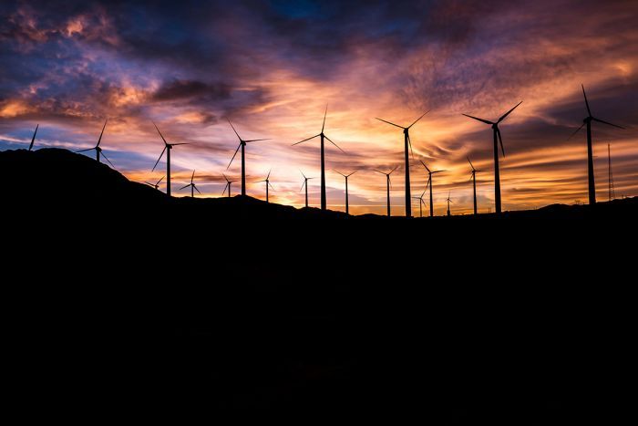 Wind farm A wind farm at sunset against an orange and purple sky.