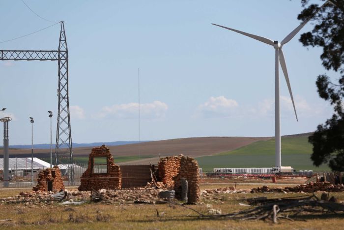 Tesla in Jamestown Building ruins with a windfarm turbine next to it