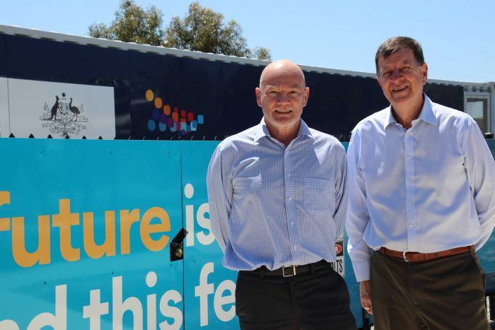 Greg Bourne Professor Andrew Stock Climate Council councillors Greg Bourne and Andrew Stock stand in front of a large community battery at Alkimos Beach.