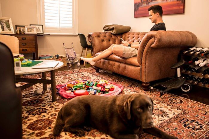 Carl Prins Home man on couch with toys and a brown dog on the ground